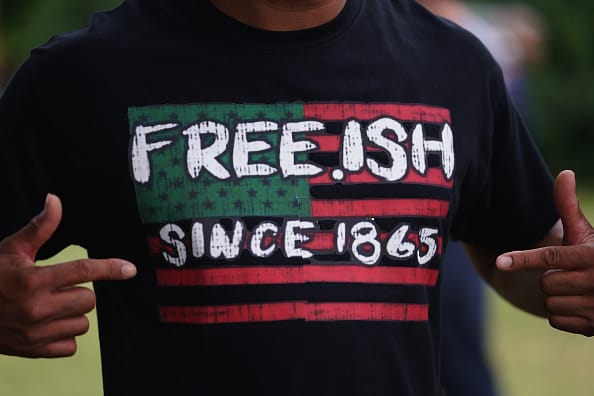 TULSA, OK - JUNE 19: A man displays a shirt celebrating the freedom of enslaved Black people during the Juneteenth celebration in the Greenwood District on June 19, 2020 in Tulsa, Oklahoma. Juneteenth commemorates June 19, 1865, when a Union general read orders in Galveston, Texas stating all enslaved people in Texas were free according to federal law. (Photo by Michael B. Thomas/Getty Images)