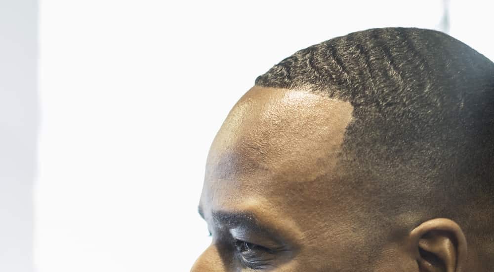 Black man styling pomade for waves