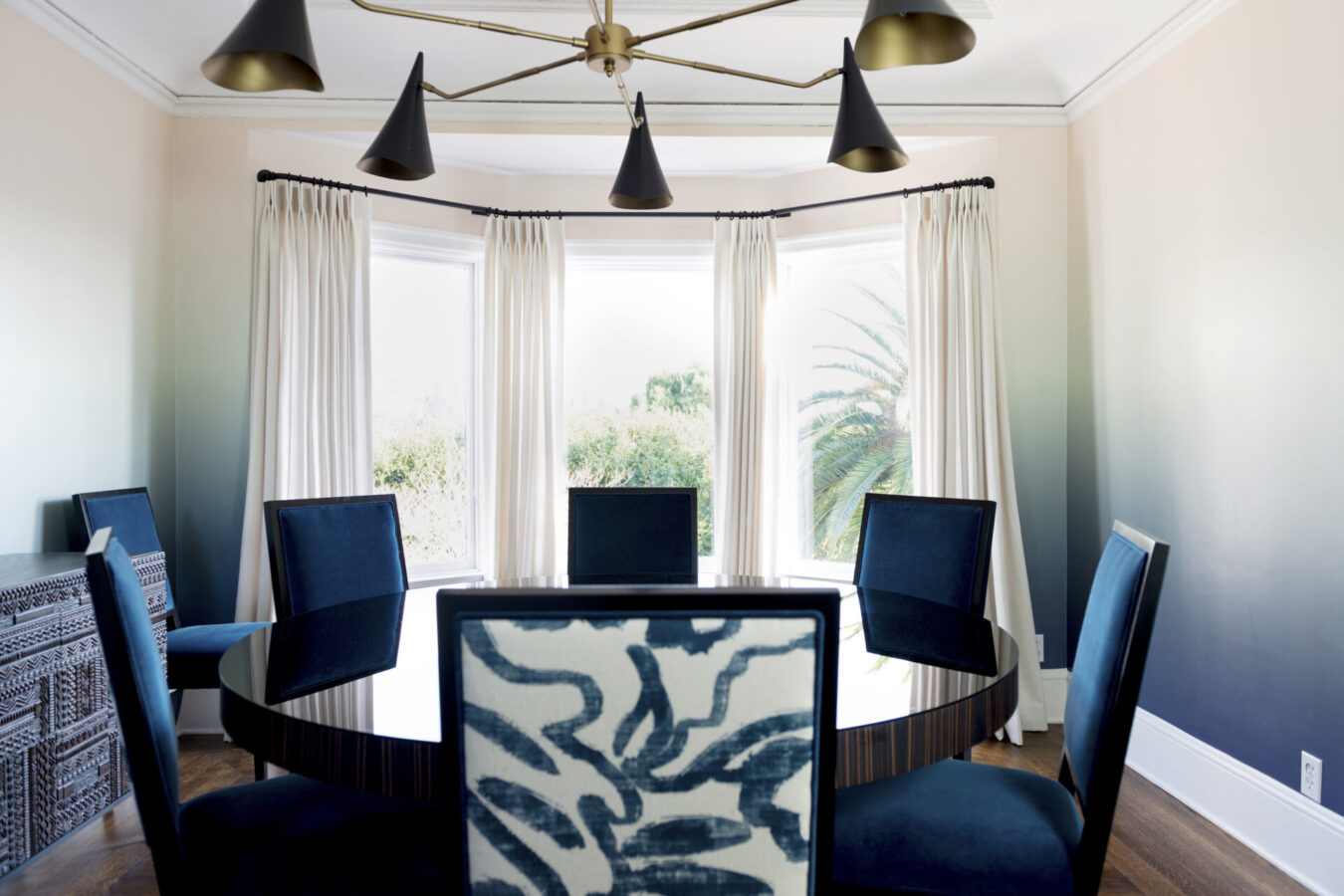 Interior design featuring blue dining chairs and gold lighting features by Kelly Finley black owned interior design firm