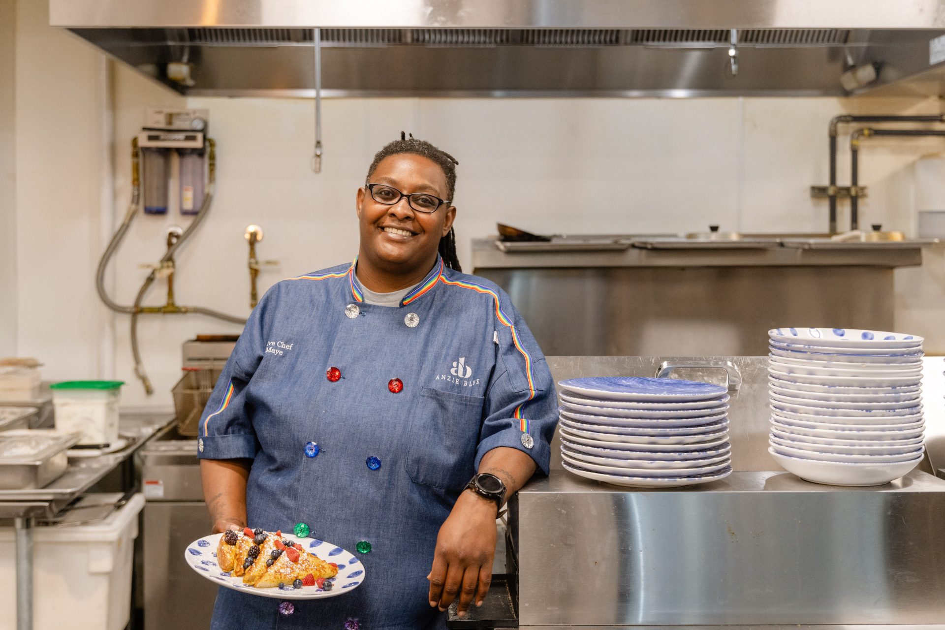 Southern Black female chef Star Maye holding a plate of french toast in an industrial kitchen