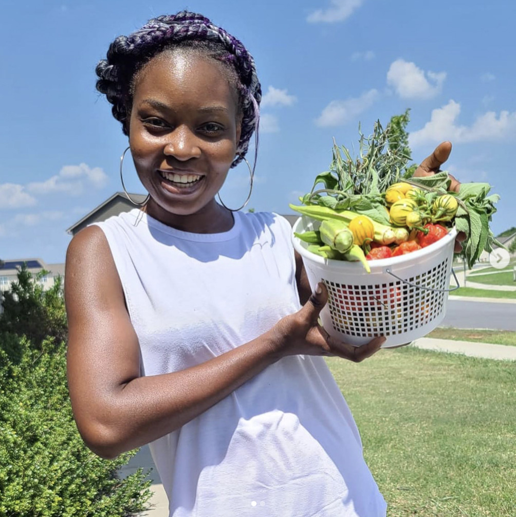 Black female chef Awo Amenumey holding a basket of vegetables