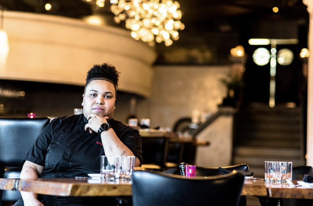 Black female chef Whitney Thomas posing in a restaurant