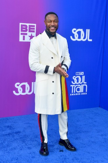 Tank in a white overcoat with blye, yellow and red stripes. Image: Aaron J. Thornton/FilmMagic for Getty Images