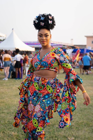 Butterly hair accents and a multicolor floral ensemble conjure bohemian vibes at Afrochella 2022. Photo by Ernest Ankomah.