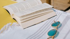 book and sunglasses on beach towel for summer sci-fi reads