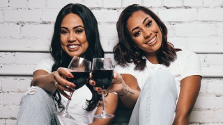 Ayesha Curry and Sydel Curry-Lee holding glasses of Domaine Curry Wine